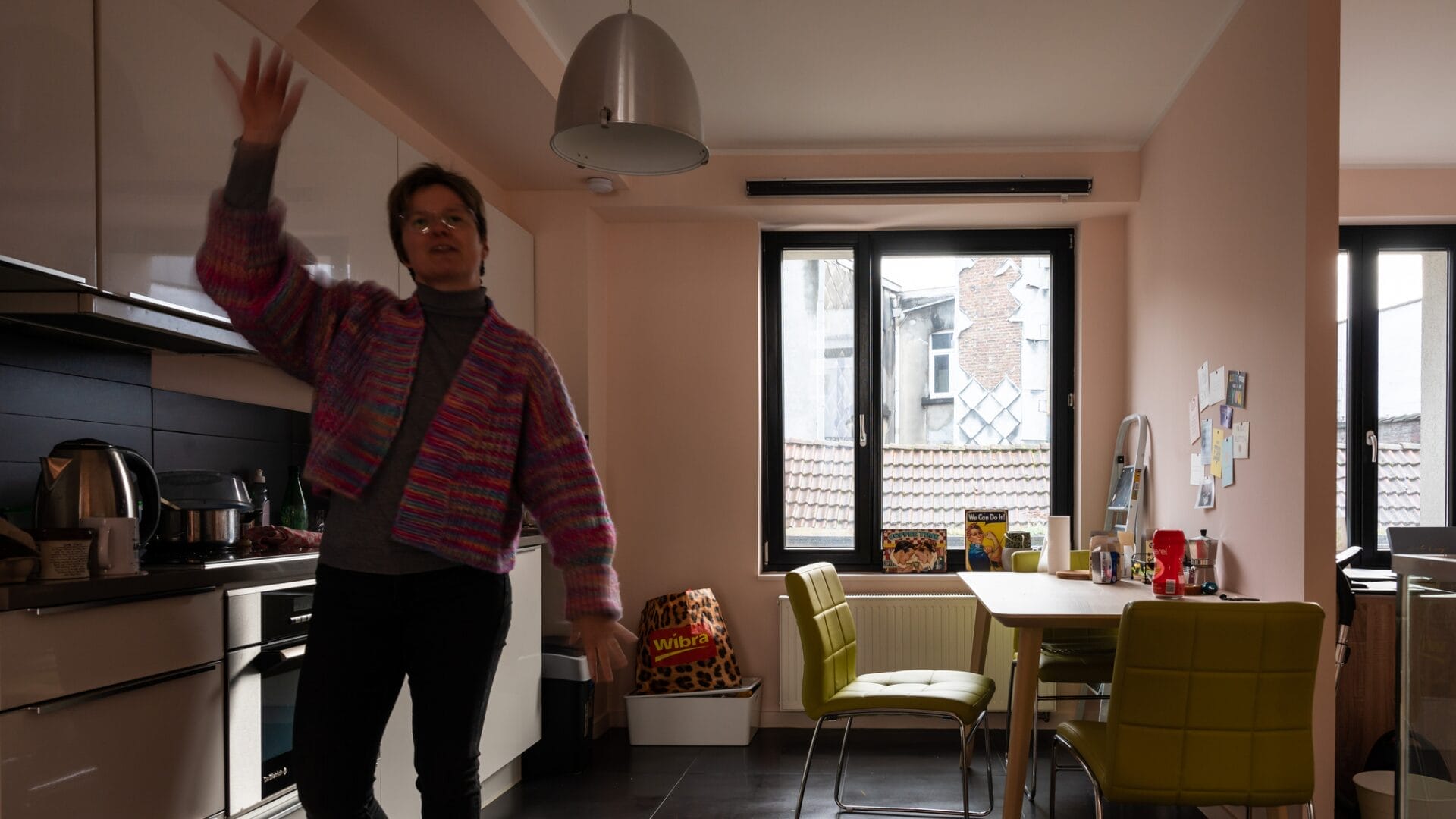 A woman standing in her kitchen in a container.