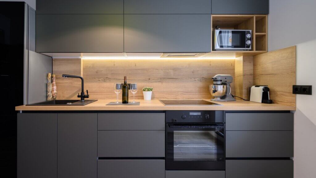 A modern, spacious, and luxurious kitchen in a sleek dark gray design.