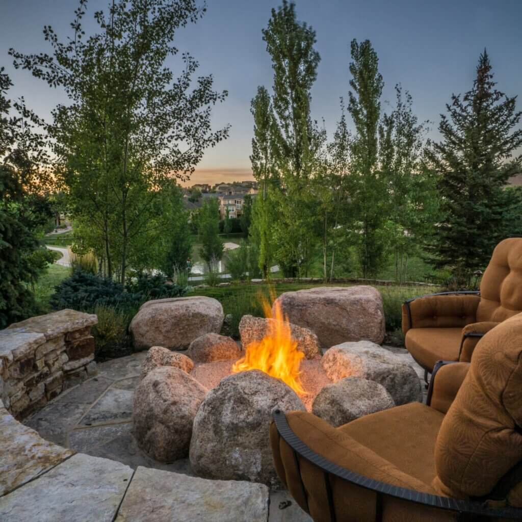 Surround the fire pit with lush, green grass to create an inviting and relaxing atmosphere.