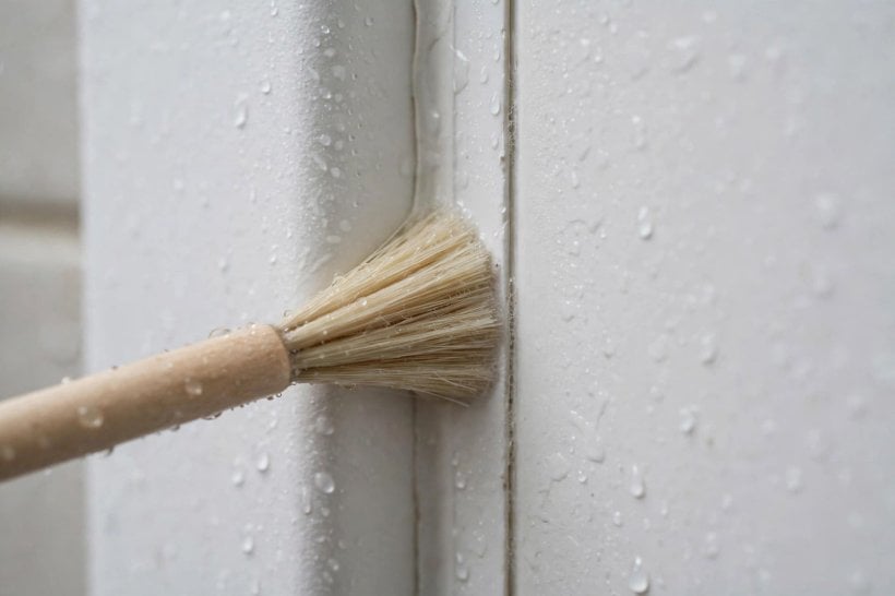 how to clean plastic shower surround: leaving soapy water to soften soap scum on the panels