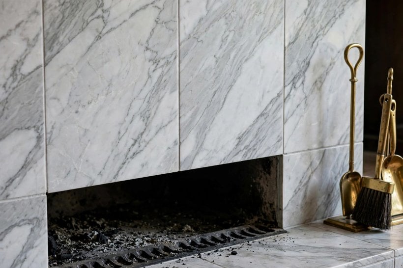 covering brick fireplace with tile: textured stone veneer surround in a calm living room