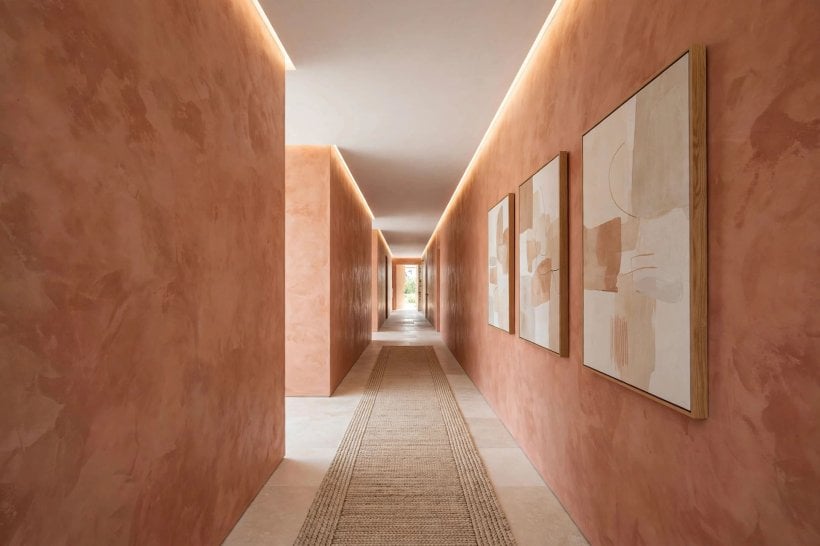 hallway wall ideas: warm wall lights washing a panelled passage
