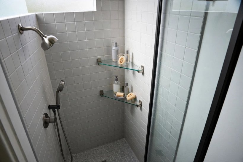 shower shelf ideas: tiled built-in niche holding bottles inside a shower wall