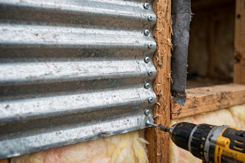 corrugated metal siding: a dense fastener pattern keeping horizontal panels flat between studs