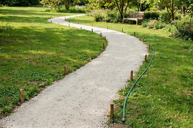 Gravel Path with Rock Borders: a curved route marked along the lawn's desire line toward a garden bench