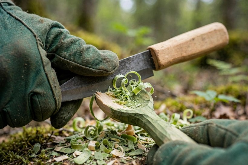 Green-Wood Bowls and Spoons: gloved hands making a controlled cut on a spoon bowl with curled shavings