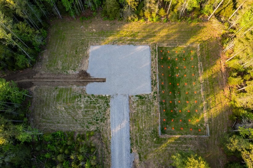 how to prepare land for a tiny house: aerial view of a finished prepared site with driveway, pad and fenced drain field