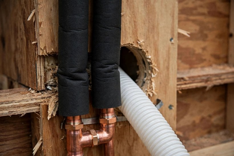 how to install a mini-split in a tiny house: an insulated copper line set pair passing through a wall penetration
