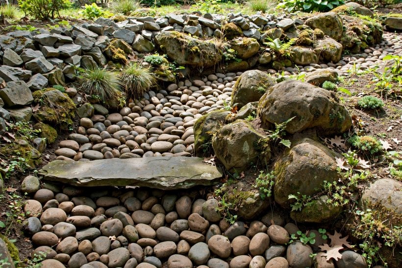 River Rock Dry Creek Bed: cobble bed with a flat riffle sill across the channel and boulders clustered at the bend