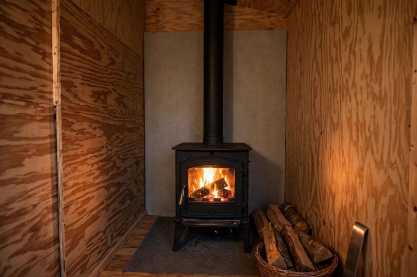 sheathing weight calculator: small wood stove with a fire-resistant board panel behind it