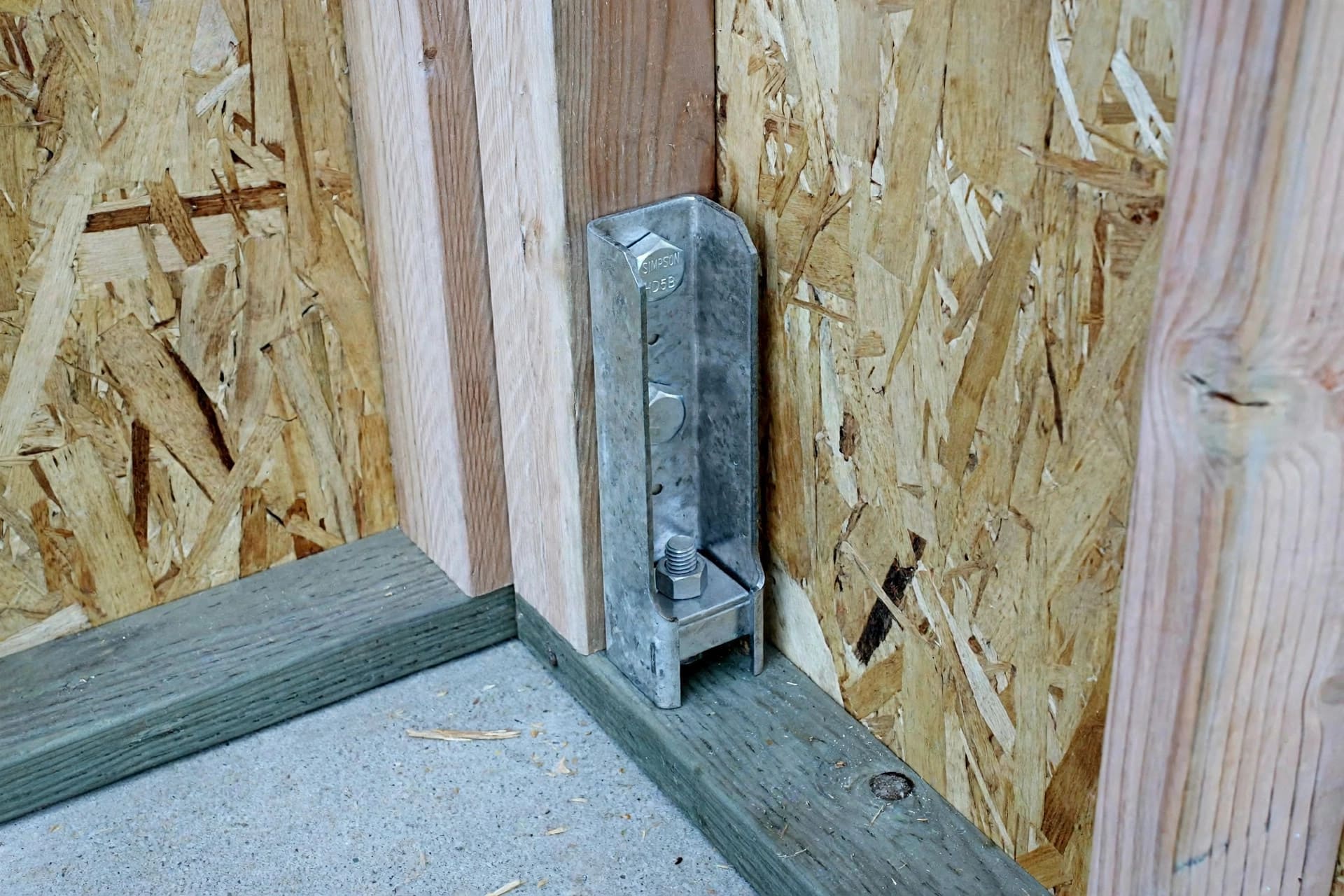 tiny house wind load shear calculator: hold-down bracket anchoring a shear wall at its base
