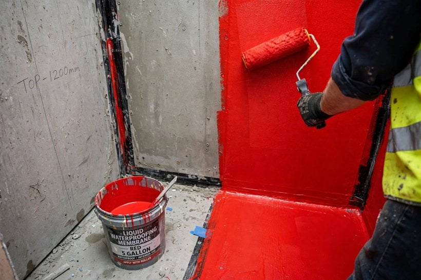 how to waterproof a tiny house bathroom: liquid membrane rolled over cement board walls, banded at the corners