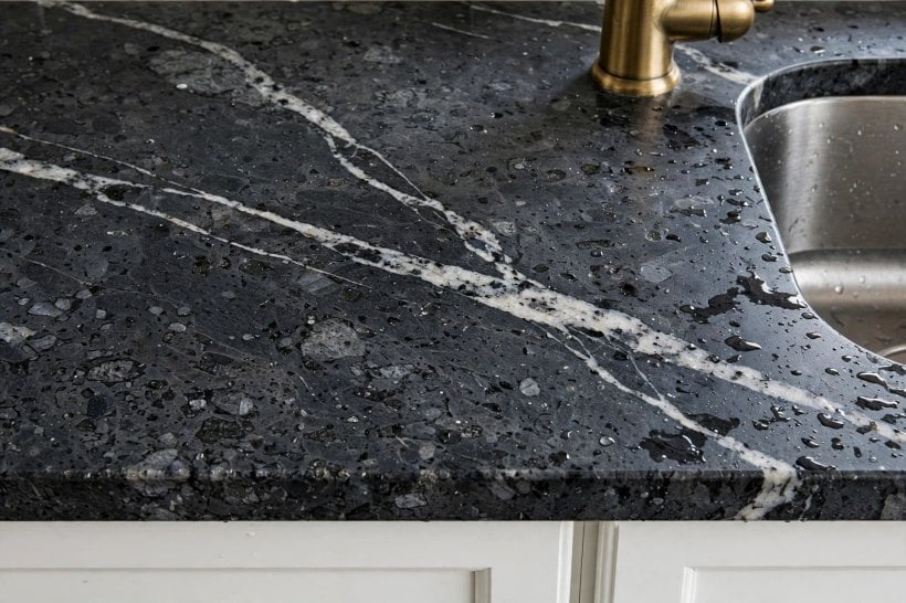 gray granite countertops with white cabinets: eased edge profile softening a dark stone worktop